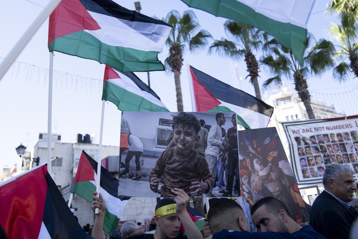 Palestinian shops are closed during a general strike in solidarity with Gaza at the commercial center of the West Bank city of Ramallah, Monday, Dec. 11, 2023. Arabic reads a new dawn in the life of the Arab nation. (AP Photo/Nasser Nasser)