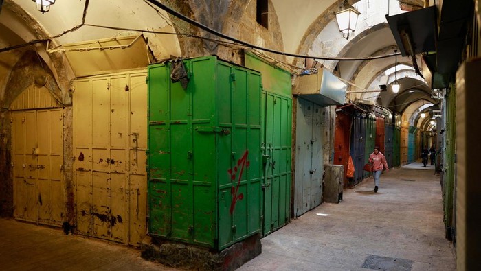 A person walks near closed shops during a strike in support of Gaza, amid the ongoing conflict between Israel and the Palestinian Islamist group Hamas, in Jerusalem's Old City, December 11, 2023. REUTERS/Ammar Awad