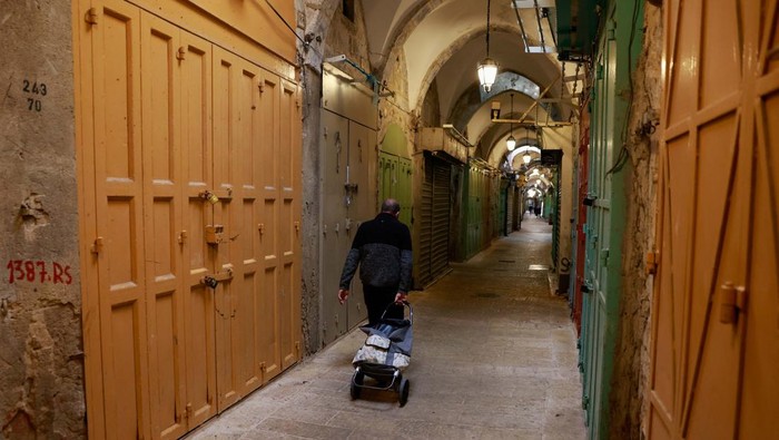 Solidaritas untuk Gaza, Pedagang di Kota Tua Yerusalem Tutup Toko A person walks near closed shops during a strike in support of Gaza, amid the ongoing conflict between Israel and the Palestinian Islamist group Hamas, in Jerusalem's Old City, December 11, 2023. REUTERS/Ammar Awad