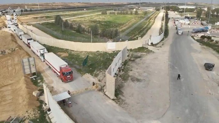 Antre Pemeriksaan, Truk Bantuan Palestina Tertahan di Kerem Shalom Humanitarian aid trucks wait in line to be inspected at the Kerem Shalom crossing, amid the ongoing conflict between Israel and the Palestinian Islamist group Hamas, on the border between Israel, Gaza and Egypt in this still image taken from video released December 12, 2023. COGAT via X/Handout via REUTERS THIS IMAGE HAS BEEN SUPPLIED BY A THIRD PARTY. NO RESALES. NO ARCHIVES. MANDATORY CREDIT. WATERMARK FROM SOURCE