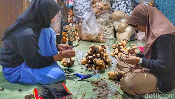 Dua honorer Bandung tengah memproduksi boneka wisuda.
