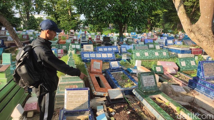 Fikriansyah menunjukkan makam ayahnya yang hilang pedapurannya
