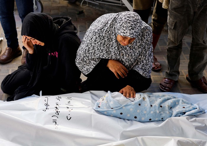 A relative of Palestinian baby Idres Al-Dbari, who was born during the war and killed in an Israeli strike in the ongoing conflict between Israel and the Palestinian Islamist group Hamas, reacts as she holds the baby at Abu Yousef al-Najjar hospital in Rafah in the southern Gaza Strip December 12, 2023. REUTERS/Mohammed Salem