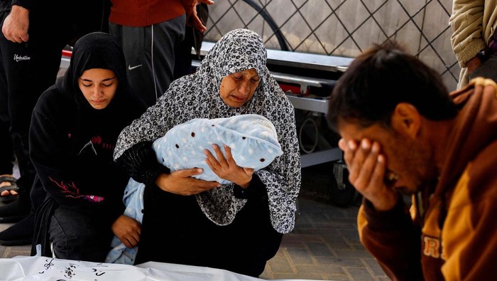 A relative of Palestinian baby Idres Al-Dbari, who was born during the war and killed in an Israeli strike in the ongoing conflict between Israel and the Palestinian Islamist group Hamas, reacts as she holds the baby at Abu Yousef al-Najjar hospital in Rafah in the southern Gaza Strip December 12, 2023. REUTERS/Mohammed Salem