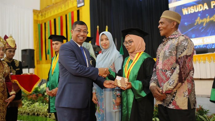Kemenperin Wisuda Ribuan Siswa, Sepanjang 2023 Mayoritas Sudah Terserap Industri Kepala Badan Pengembangan Sumber Daya Manusia Industri (BPSDMI) Kemenperin Masrokhan (kiri) memberikan toga pelantikan wisuda SMK-Banda Aceh di Banda Aceh, Senin (11/12/2023). Kementerian Perindustrian melantik 5.673 siswa dan mahasiswa SMK, Politeknik, dan Akademi Komunitas Kemenperin sepanjang tahun 2023 dengan 87% lulusan SMK dan 74% lulusan Politeknik & Akom sudah terserap di industri.