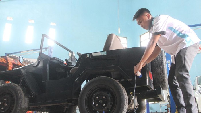 Pelajar menunjukkan cara pengisian ulang baterai mobil listrik yang diberi nama Jeep K10 di laboratorium otomotif SMK 10 Malang, Jawa Timur, Rabu (13/12/2023). Kendaraan listrik berupa motor dan mobil jip hasil inovasi pelajar tersebut menggunakan baterai rakitan bertegangan 72 volt sehingga memiliki daya penyimpanan lebih besar serta berbiaya lebih murah jika dibandingkan kendaraan listrik buatan pabrik. ANTARA FOTO/Ari Bowo Sucipto/foc.