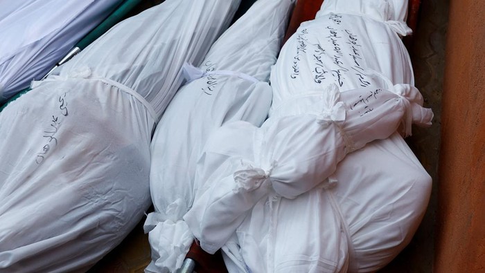 Korban Tewas Perang Israel-Palestina di Gaza Tembus 18 Ribu Jiwa People mourn near the bodies of Palestinians killed in Israeli strikes on houses, at Abu Yousef al-Najjar hospital in Rafah in the southern Gaza Strip, December 7, 2023. REUTERS/Ibraheem Abu Mustafa