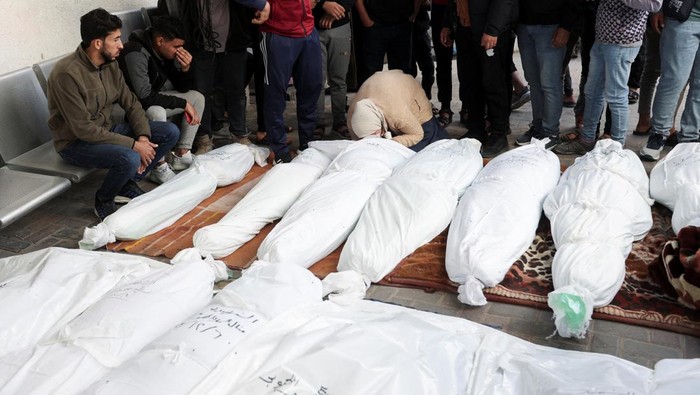 People mourn near the bodies of Palestinians killed in Israeli strikes on houses, at Abu Yousef al-Najjar hospital in Rafah in the southern Gaza Strip, December 7, 2023. REUTERS/Ibraheem Abu Mustafa
