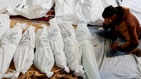 Seorang pelayat nampak tak kuasa menahan tangis di dekat sejumlah jenazah korban perang di rumah sakit Abu Yossef Al-Najar, di Rafah di selatan Jalur Gaza, Selasa (12/12/2023). REUTERS/Mohammed Salem