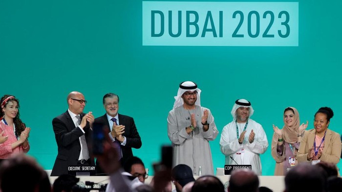 COP28 president Sultan Ahmed Al Jaber (C) applauds among other officials before a plenary session during the United Nations climate summit in Dubai on December 13, 2023. Nations adopted the first ever UN climate deal that calls for the world to transition away from fossil fuels. 