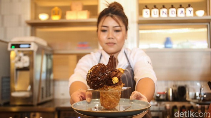 Nongkrong di Sini Nyamannya Seperti 'Hari Minggu' Karyawan menunjukan menu soft ice cream di Gerai Hello Sunday Margo City, Depok, Jawa Barat, Selasa (12/12/2023).