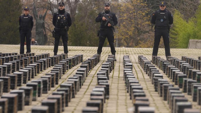 Penampakan 11 Ton Kokain yang Disita Polisi Spanyol Police officers stand by part of a haul of 11 tons of cocaine, displayed in the patio of a police station in Madrid, Spain, Tuesday, Dec. 12, 2023. Spanish authorities say that they have confiscated 11 tons of cocaine and arrested 20 people in two different operations against the smuggling of the illegal drugs inside shipping containers. Investigators believe that the criminal organization was using a frozen seafood company as a front to bring the drug from South America. (AP Photo/Paul White)