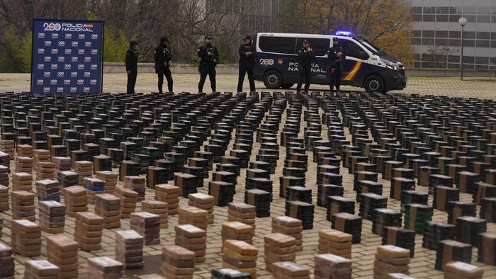Penampakan 11 Ton Kokain yang Disita Polisi Spanyol Police officers stand by part of a haul of 11 tons of cocaine, displayed in the patio of a police station in Madrid, Spain, Tuesday, Dec. 12, 2023. Spanish authorities say that they have confiscated 11 tons of cocaine and arrested 20 people in two different operations against the smuggling of the illegal drugs inside shipping containers. Investigators believe that the criminal organization was using a frozen seafood company as a front to bring the drug from South America. (AP Photo/Paul White)