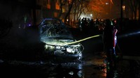 Petugas berusaha memadamkan api yang membakar sebuah mobil yang terkena rudal.  