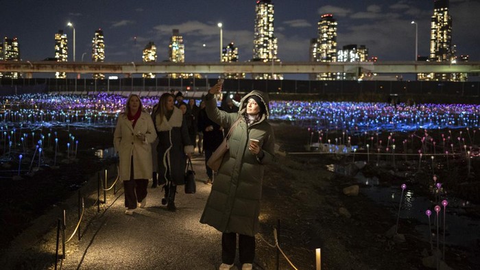 People walk in the public art installation 