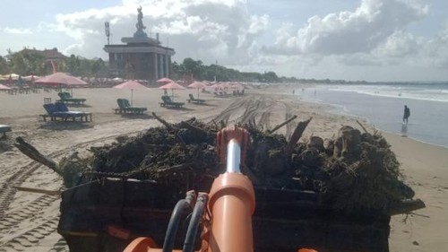 Alat berat membersihkan pantai dari sampah kayu di pantai beberapa waktu lalu.