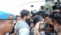 Ammar Zoni terlihat memakai kaus putih dan jaket berwarna abu-abu putih. Dia juga terlihat memakai masker berwarna hitam. Foto: Febri/detikHOT