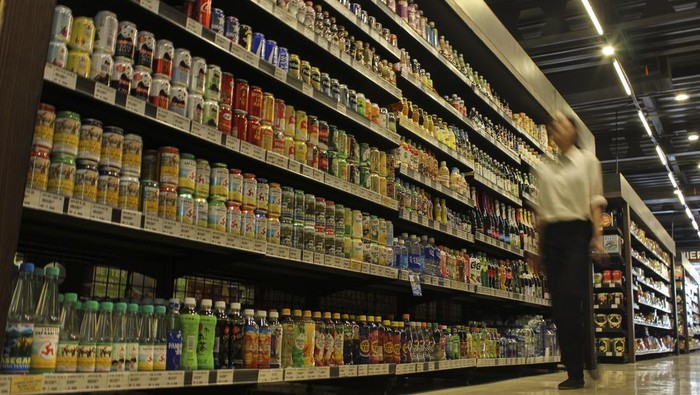 Warga melintas di samping rak berisi minuman berpemanis di salah satu toko retail, Jakarta, Kamis (14/12/2023). Hasil survei Yayasan Lembaga Konsumen Indonesia (YLKI) menunjukkan 58 persen dari 800 responden mendukung wacana pengenaan cukai pada minuman berpemanis dalam kemasan (MBDK) untuk mengontrol pola konsumsi dan mencegah prevalensi diabetes pada anak yang meningkat 70 kali lipat pada Januari 2023 dibandingkan tahun 2010. ANTARA FOTO/Cahya Sari/sgd/foc.