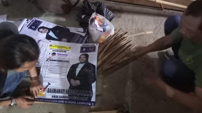 Perangkat kelurahan bantu pasang banner Caleg di Bandar Lampung.