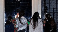 Anak-anak mengetuk pintu Downing Street No. 10 yang merupakan tempat Perdana Menteri Inggris tinggal dan berkantor, 13 Desember 2023.