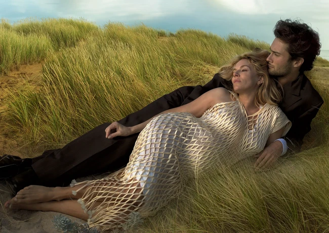 Sienna juga berpose bersama kekasihnya,Oli Green. Dalam foto tersebut, keduanya terlihat tiduran di atas rumput sambil menatap langit. Untuk pose kali ini, wanita berambut pirang itu mengenakan gaun fish net warna beige-putih. Foto: Dok. Vogue