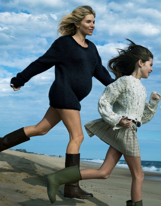 Untuk sampul majalah, Sienna mengenakan sweater tebal berukuran oversized yang dipadukan celana bikini dan boots selurut. Ia tampak berpose candid bersama putrinya yang berusia 11 tahun. Foto: Dok. Vogue
