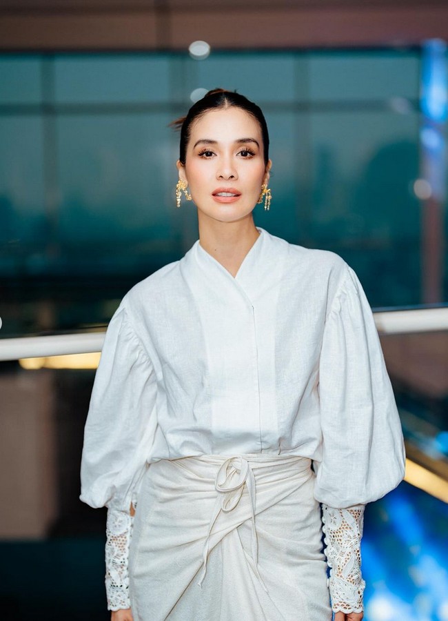 Marsha Timothy mengenakan setelan blouse dan kain dari koleksi Sejauh Mata Memandang. Busana putih terlihat cantik berkat detail lace pada bagian hem di ujung lengan serta bawah kain lilit. Foto: Instagram/@vinogbastian__ @marshatimothy @armanfebryan