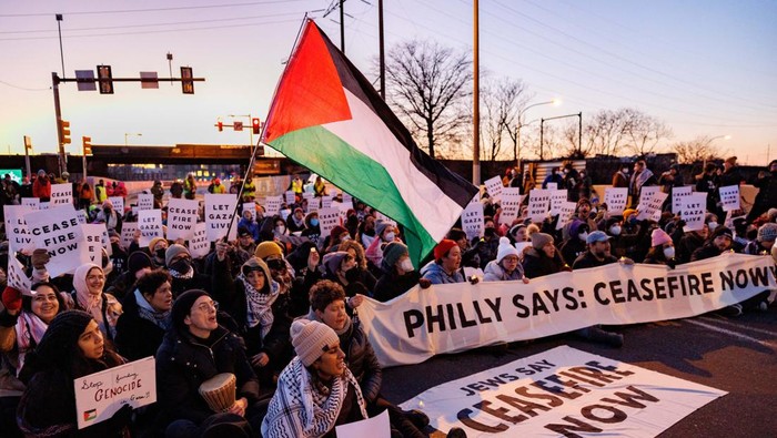 Minta Gencatan Senjata di Gaza, Massa Blokir Jalan di AS A protester from the national group Jewish Voice for Peace is arrested for blocking traffic on I-76 during a call for a ceasefire in the Israel-Hamas war during rallies across the U.S. marking the 8th night of Hanukkah, in Philadelphia, Pennsylvania, U.S., December 14, 2023. REUTERS/Hannah Beier
