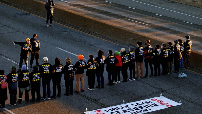 A protester from the national group Jewish Voice for Peace is arrested for blocking traffic on I-76 during a call for a ceasefire in the Israel-Hamas war during rallies across the U.S. marking the 8th night of Hanukkah, in Philadelphia, Pennsylvania, U.S., December 14, 2023.   REUTERS/Hannah Beier