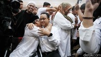 Seorang penyandang disabilitas tampak memeluk Anies Baswedan.  
