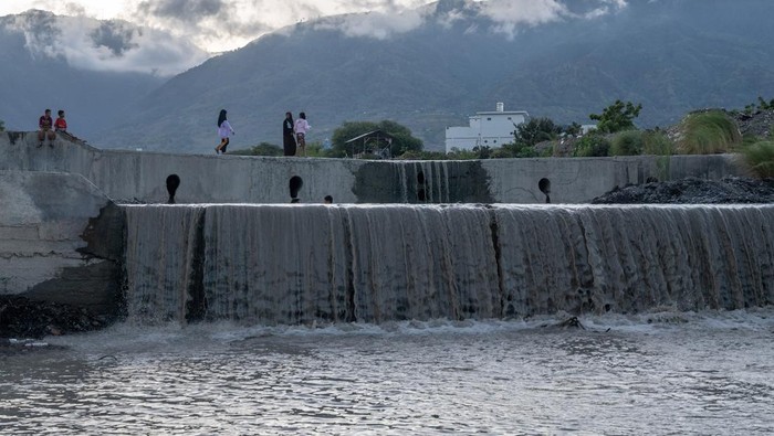 Sejumlah anak bermain di dam pengendali banjir di Duyu, Palu, Sulawesi Tengah, Jumat (15/12/2023). Keterbatasan ruang bermain menyebabkan anak-anak melakukan aktivitas bermain mereka di dam yang berisi air setelah hujan turun di wilayah itu, walaupun kegiatan tersebut cukup berbahaya. ANTARA FOTO/Basri Marzuki/Spt.