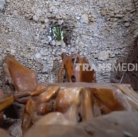 Terdapat semacam goa yang di dalamnya berfungsi sebagai ruang tamu. Adapun bangku dan mejanya terbuat dari belahan batang pohon. (Foto: YouTube/Trans7 Official)