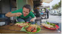 Warung kaki lima pertama yang dikunjungi Mark Wiens adalah Nasi BeTe Tongkol Bu Karmini. Mark memesan seporsi nasi tongkol berlumuran sambal dan cumi hitam. Foto: YouTube Mark Wiens