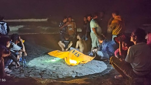 Warga dan rekan mengerubungi jasad korban hanyut di Pantai Pererenan, Badung, sebelum dibawa ke RS Mangusada, Sabtu (16/12/2023) dini hari.