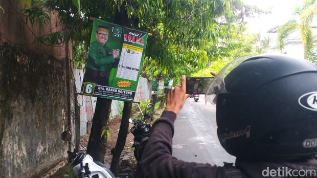 Baliho caleg terpaku di pohon di ruas Jalan Letjen Hertasning Makassar.