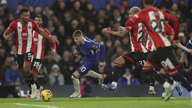 Chelsea's Cole Palmer takes the ball forward as Sheffield United's Auston Trusty, left goes to tackle during the English Premier League soccer match between Chelsea and Sheffield United at Stamford Bridge in London, Saturday, Dec. 16, 2023. (AP Photo/Ian Walton)
