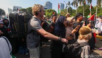 Bahkan seorang wisatawan asing terlihat menembus kerumunan bersama sang anak.