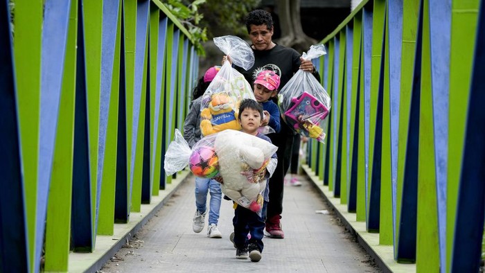 Aksi 'Sinterklas' Terjun dari Jembatan untuk Bagikan Hadiah kepada Anak-anak Firefighter Hector Chacon, dressed as Santa Claus, rappels down to give out Christmas gifts to children on the outskirts of Guatemala City on Sunday, Dec. 17, 2023. Since 1997, Chacon has been collecting toys to give at Christmas. (AP Photo/Moises Castillo)