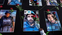 Warga menaruh bunga mawar di atas sejumlah foto jurnalis peliput konflik Israel di Gaza, Palestina pada aksi damai di Solo, Jawa Tengah, Minggu (17/12/2023).