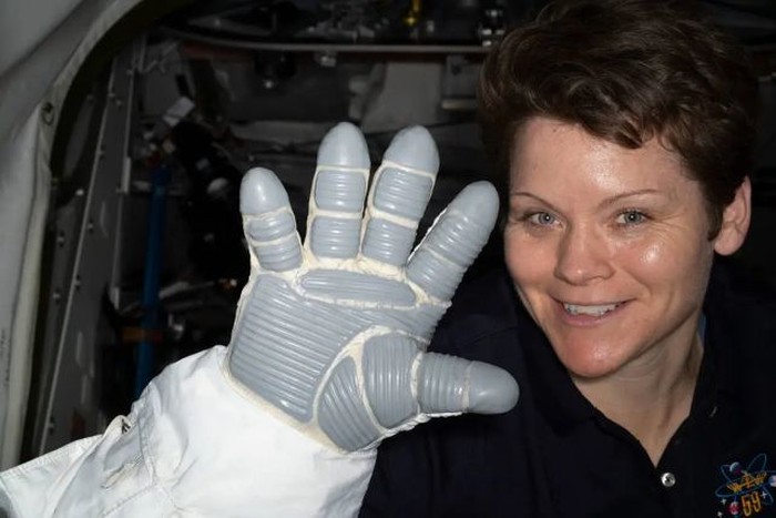 Astronaut NASA, Anne McClain menunjukkan sarung tangan pakaian antariksa pada tahun 2019.