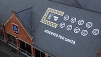 Parkiran tersebut diberi cat putih di atas bangunan yang disediakan khusus untuk Santa dan kereta luncur yang digerakan oleh rusa kutub.