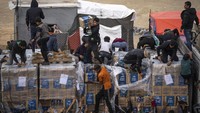 Lusinan warga Palestina mengepung truk bantuan setelah mereka melewati penyeberangan Rafah dengan Mesir, memaksa beberapa orang untuk berhenti sebelum naik ke kapal, menurunkan kotak makanan dan air, dan membawanya atau memberikannya kepada orang banyak di bawah.