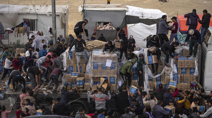 Palestinians loot a humanitarian aid truck as it crossed into the Gaza Strip in Rafah, Sunday, Dec. 17, 2023. (AP Photo/Fatima Shbair)