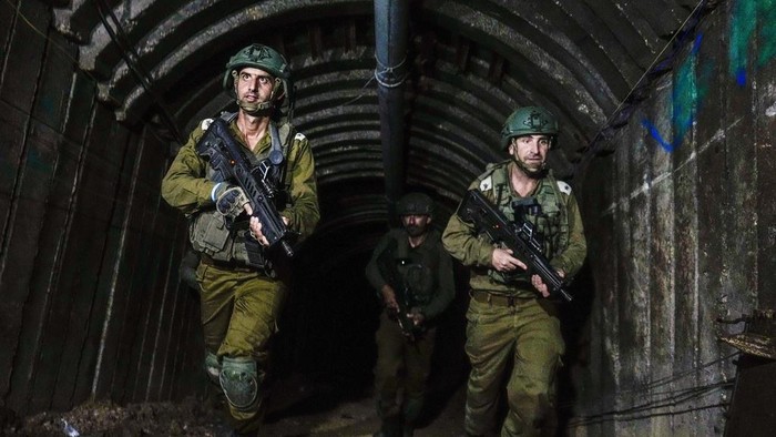 Israeli soldiers are seen in a tunnel that the military says Hamas militants used to attack the Erez crossing in the northern Gaza Strip, Friday, Dec. 15, 2023. The army is battling Palestinian militants across Gaza to retaliate for Hamas Oct. 7 attack on Israel. (AP Photo/Ariel Schalit)