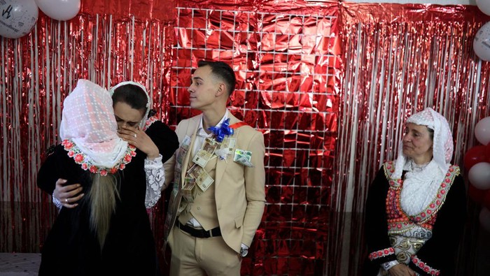 Bulgarian Muslim bride Aysel Gerova, 24, and her groom Ahmed Gyuliov, 23, welcome guests during their wedding ceremony in the village of Ribnovo, in the Rhodope Mountains, Bulgaria, December 17, 2023. The village of Ribnovo has kept its traditional winter marriage ceremony alive after decades of Communist rule. The wedding ritual was resurrected among the Pomaks. The highlight of the ceremony is the painting of the bride's face, where in a private rite open only to female in-laws, her face is covered in thick, chalky white paint and decorated with colourful sequins. REUTERS/Stoyan Nenov
