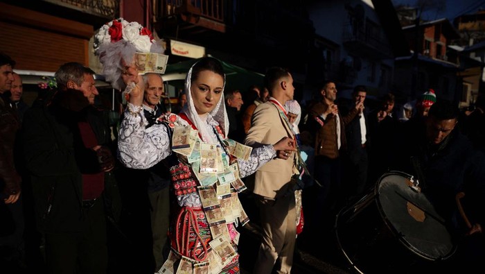 Bulgarian Muslim bride Aysel Gerova, 24, and her groom Ahmed Gyuliov, 23, welcome guests during their wedding ceremony in the village of Ribnovo, in the Rhodope Mountains, Bulgaria, December 17, 2023. The village of Ribnovo has kept its traditional winter marriage ceremony alive after decades of Communist rule. The wedding ritual was resurrected among the Pomaks. The highlight of the ceremony is the painting of the bride's face, where in a private rite open only to female in-laws, her face is covered in thick, chalky white paint and decorated with colourful sequins. REUTERS/Stoyan Nenov