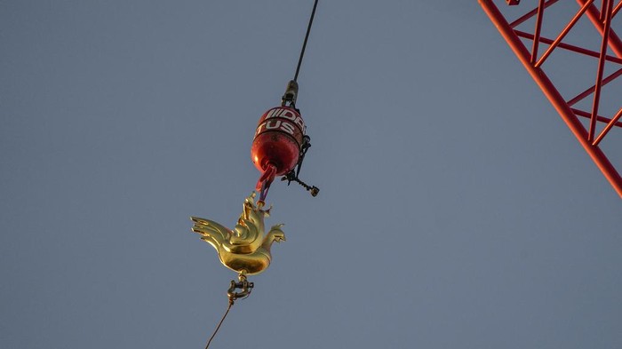 The replica of the golden rooster is craned up to the top of the Notre Dame cathedral spire as part of restoration works Saturday, Dec. 16, 2023, in Paris. Notre Dame Cathedral got its rooster back Saturday, in a pivotal moment for the Paris landmark's restoration following the devastating fire in April 2019. (AP Photo/Michel Euler)