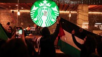 Massa Pro-Palestina mengibarkan bendera Palestina di depan kedai kopi Starbucks di Barcelona, Spanyol, Sabtu (16/12/2023).