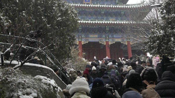 Potret Ribuan Orang Berdesakan untuk Lihat Salju di Kota Terlarang China The snow covered Forbidden City is seen from a hilltop pavilion in Beijing, Wednesday, Dec. 13, 2023. Throngs of people in boots and down parkas climbed a hill that overlooks the Forbidden City this week to jostle with others trying to get a shot of the snow-covered roofs of the former imperial palace. (AP Photo/Ng Han Guan)