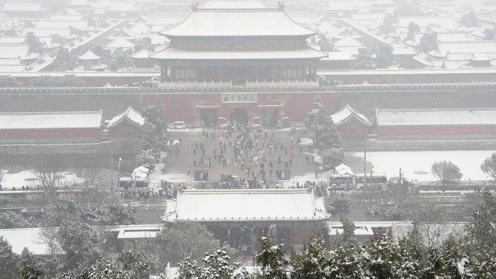 The snow covered Forbidden City is seen from a hilltop pavilion in Beijing, Wednesday, Dec. 13, 2023. Throngs of people in boots and down parkas climbed a hill that overlooks the Forbidden City this week to jostle with others trying to get a shot of the snow-covered roofs of the former imperial palace. (AP Photo/Ng Han Guan)